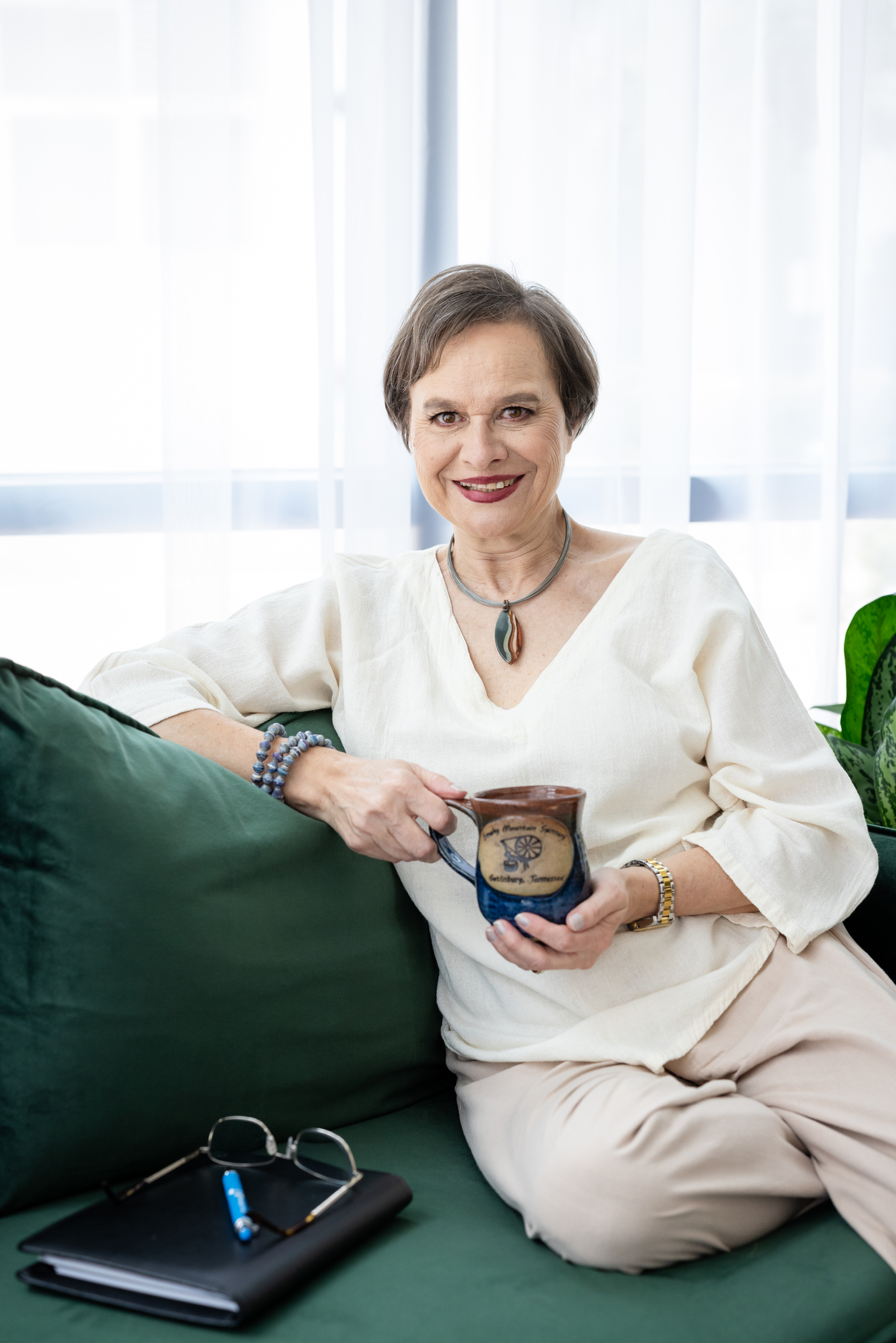 Luiza sitting on couch with coffee mug